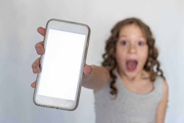 Foto niña borrosa con un teléfono en las manos