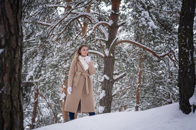 niña en bosque de invierno con árboles blancos y nieve abundante