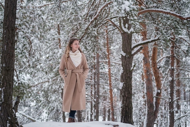 Foto niña en bosque de invierno con árboles blancos y nieve abundante