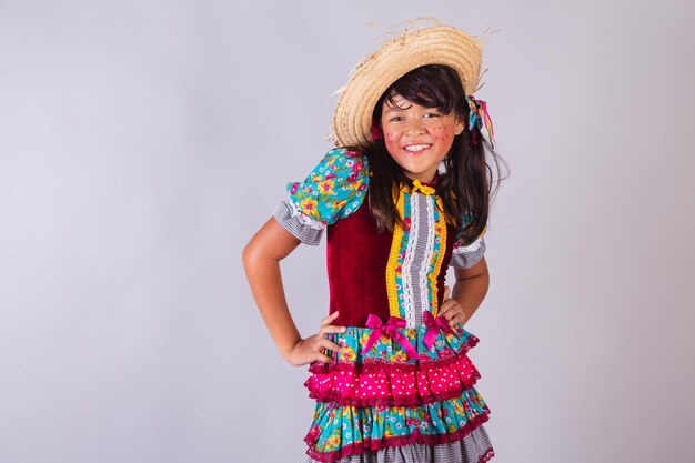 Foto niña brasileña en ropa de festa junina con sombrero de paja
