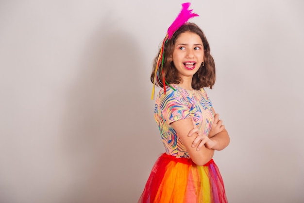 Niña brasileña vestida con traje de carnaval con los brazos cruzados