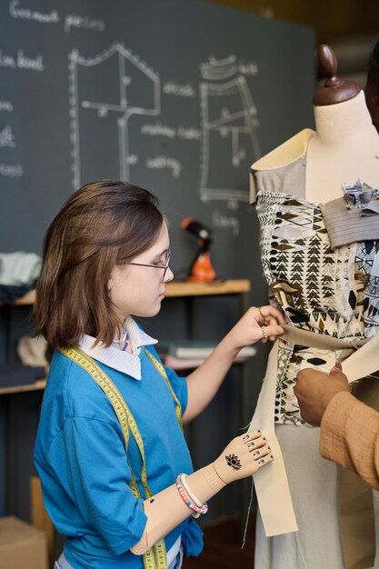 Niña con brazo protésico estudiando diseño de ropa