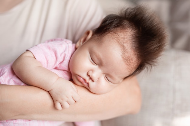 una niña en los brazos de su madre sobre un fondo claro