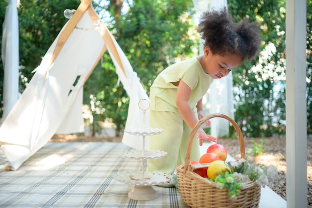 Una niña brillante y linda con diversión jugando en el jardín de la casa