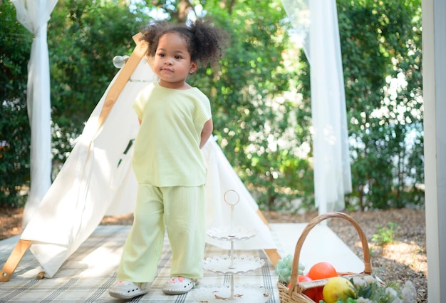 Una niña brillante y linda con diversión jugando en el jardín de la casa