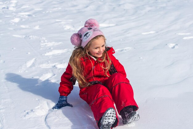 Niña cabalgando sobre toboganes de nieve en invierno. Navidad y próspero año nuevo.