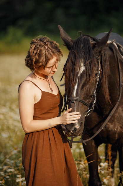 Una niña con un caballo, un vestido marrón, un hombre en la naturaleza con un animal.