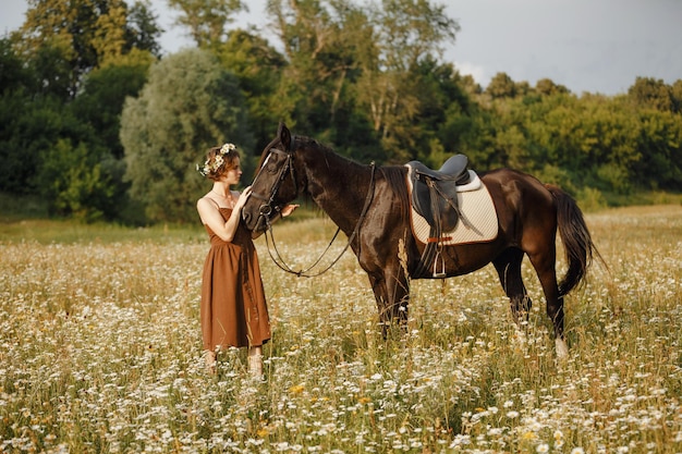 Una niña con un caballo, un vestido marrón, un hombre en la naturaleza con un animal.