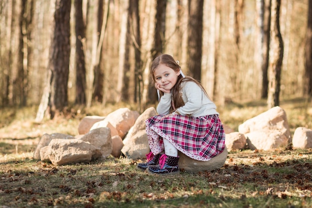 niña con cabello largo sentado en el bosque