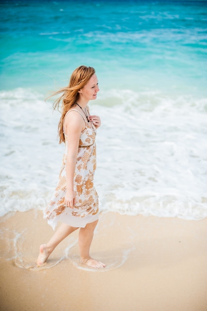 La niña camina al borde del agua en el Boracay