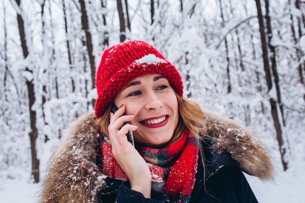 Una niña camina en un bosque nevado de invierno