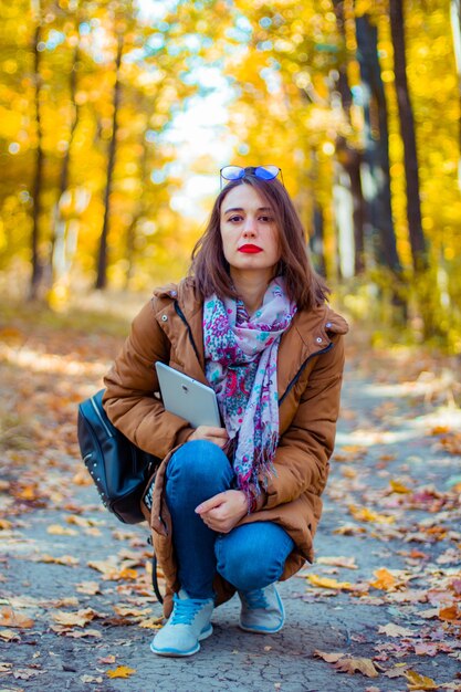 La niña camina en el bosque de otoño.