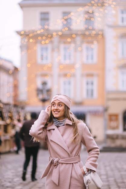 Niña camina por la calle del mercado de Navidad, decorado para Navidad