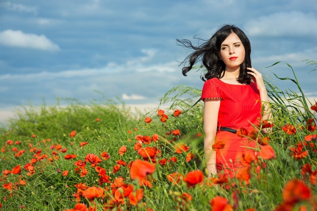 Niña camina en un campo de amapolas