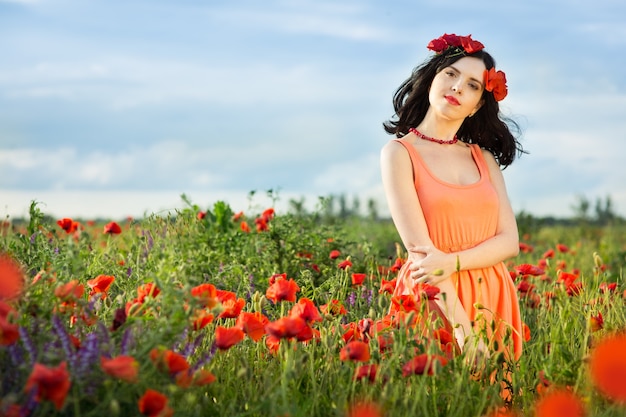 Niña camina en un campo de amapolas