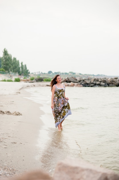 Una niña camina en el mar.