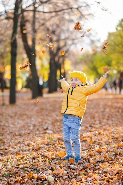 Una niña camina en el parque de otoño.