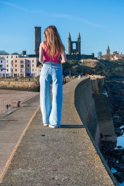 Una niña camina por el paseo marítimo de la ciudad de St Andrews en el Reino Unido