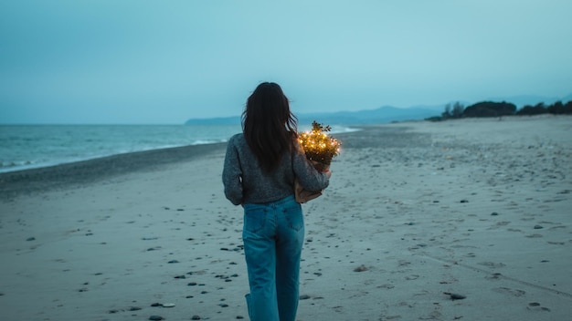 Niña camina por la playa a la hora azul