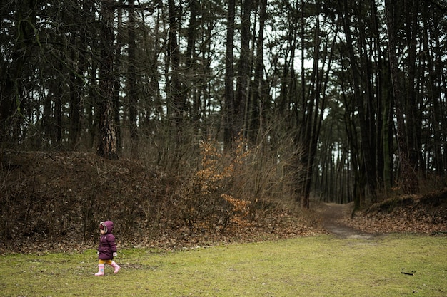 Niña caminando por el bosque después de la lluvia