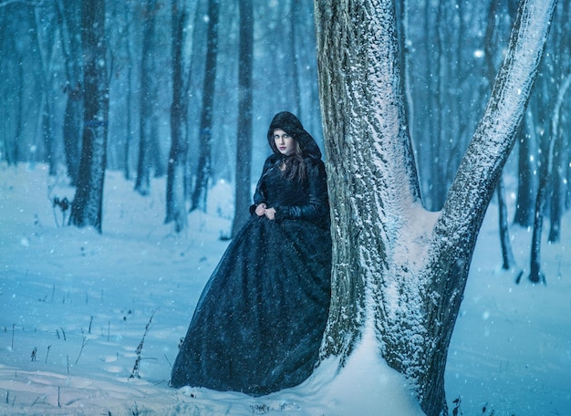 Niña caminando en el bosque de invierno