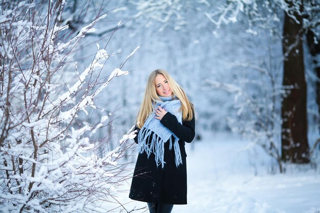 Niña caminando bosque nevado y sonriendo a la cámara