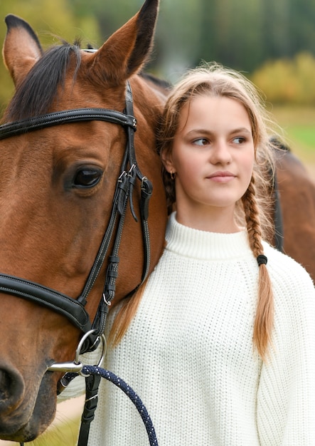 Niña caminando con un caballo en la naturaleza.