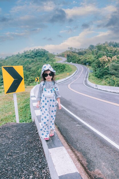 Foto niña caminando por la carretera parece el número 3