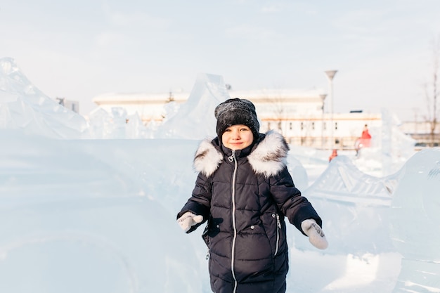 Niña caminando en invierno, esculturas de hielo de invierno, gorro y chaqueta