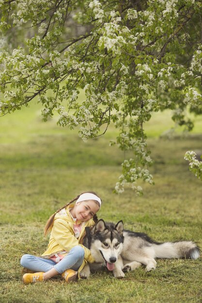 Niña caminando en el parque y jugando con su mascota mejor amigo divertido malamute perro de alaska