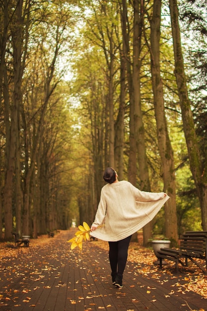 niña caminando en el parque en otoño