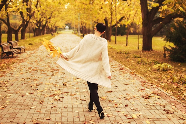 niña caminando en el parque en otoño