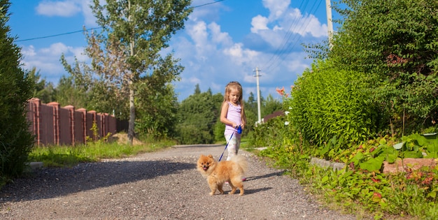 Niña caminando con su perro con una correa