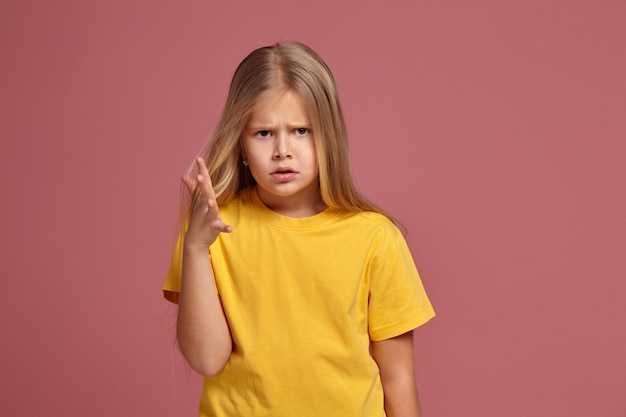 Niña en una camiseta amarilla lo entrega inquisitivamente