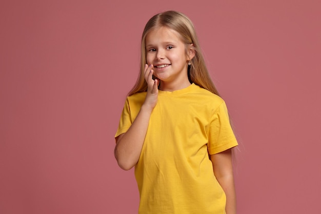 Niña con una camiseta amarilla. mirando tímidamente