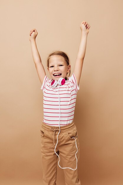 Niña en camiseta a rayas auriculares gesto manos infancia inalterada