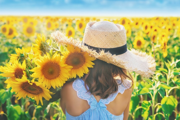 Niña en un campo de girasoles florecientes