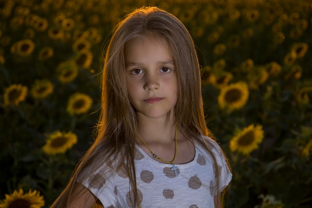 Niña en el campo con girasoles fondo borroso