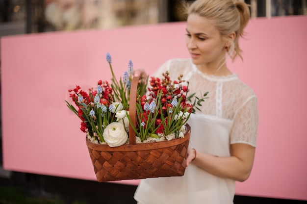 Niña con canasta de flores rojas y azules