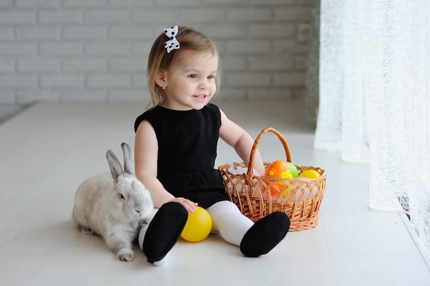 Niña con canasta de pascua y conejito de pascua