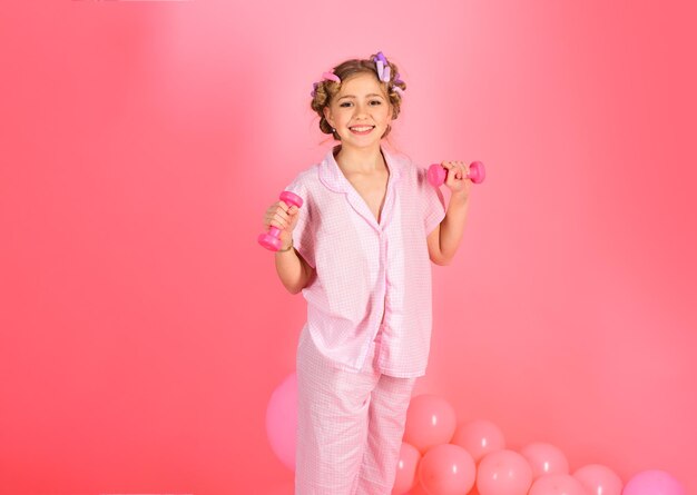 Niña con una cara sonriente levantando una barra