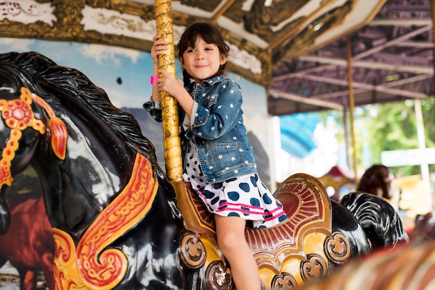 Niña en un carrusel de caballo