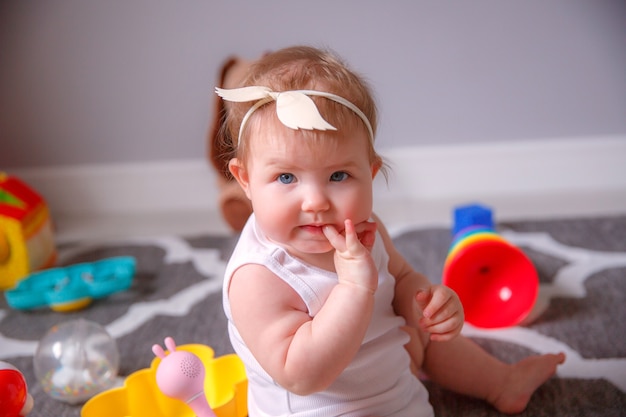 Niña en casa sentada en el suelo jugando con juguetes