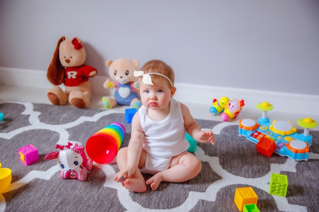 Niña en casa sentada en el suelo jugando con juguetes