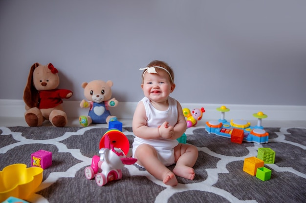 Niña en casa sentada en el suelo jugando con juguetes