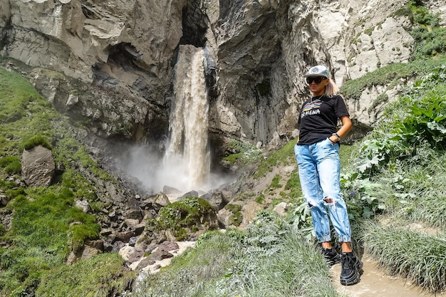 Una niña en la cascada Sultansu rodeada por las montañas del Cáucaso cerca de Elbrus Jilysu Rusia