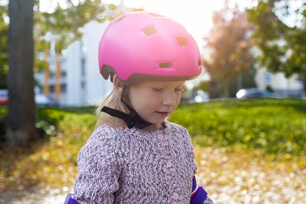 Niña en un casco rosa en protección en el parque