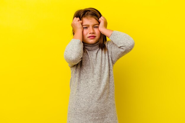 Niña caucásica aislada en amarillo llorando, infeliz con algo, concepto de agonía y confusión.