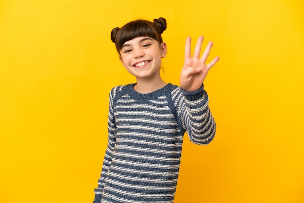 Niña caucásica aislada feliz y contando cuatro con los dedos