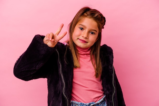 Niña caucásica aislada en rosa mostrando el número dos con los dedos.